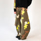 Person wearing camouflage-patterned barrel leg pants with a cropped hoodie with matching print on a white background