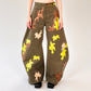Person wearing camouflage-patterned barrel leg pants on a white background
