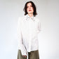 White stripped shirt with black ant hand embroidered designs on a plain background