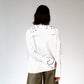 White stripped shirt with black ant hand embroidered designs on a plain background