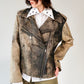 Person wearing a patterned black and brown soft lambskin leather aviator style jacket over a white shirt with black embroidered ant designs on a light gray background. made by mucina studio in latvia