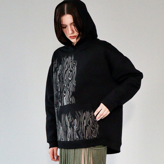 person wearing a limited quantity black french terry heavyweight hoodie with screen print graphic on front. hoodie made in riga, latvia