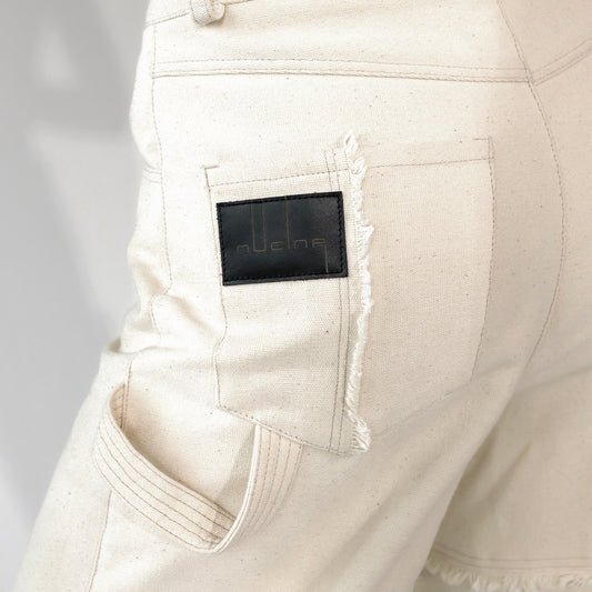 close up of Beige barrel-leg cargo pants with patch detailing with leather embossed logo label