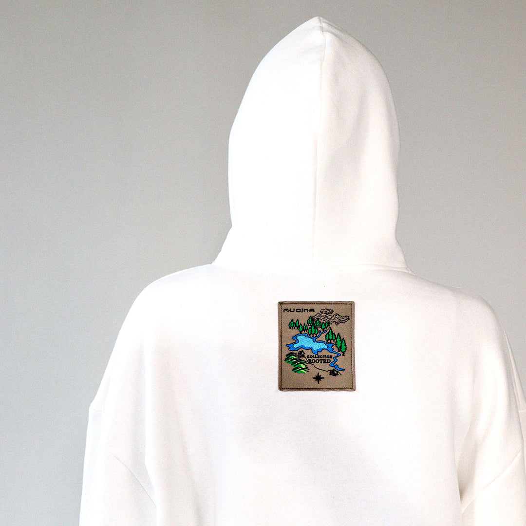 close up of embroidered nature motif label  on the back of a white hoodie