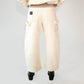 Beige barrel-leg cargo pants with patch detailing worn with a beige bomber jacket on a white background