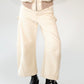 Beige barrel-leg cargo pants with patch detailing worn with a beige bomber jacket on a white background