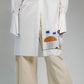 White shirt with colorful hand embroidery on a gray background