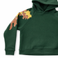 Green hoodie with dinosaur designs on the sleeves against a white background