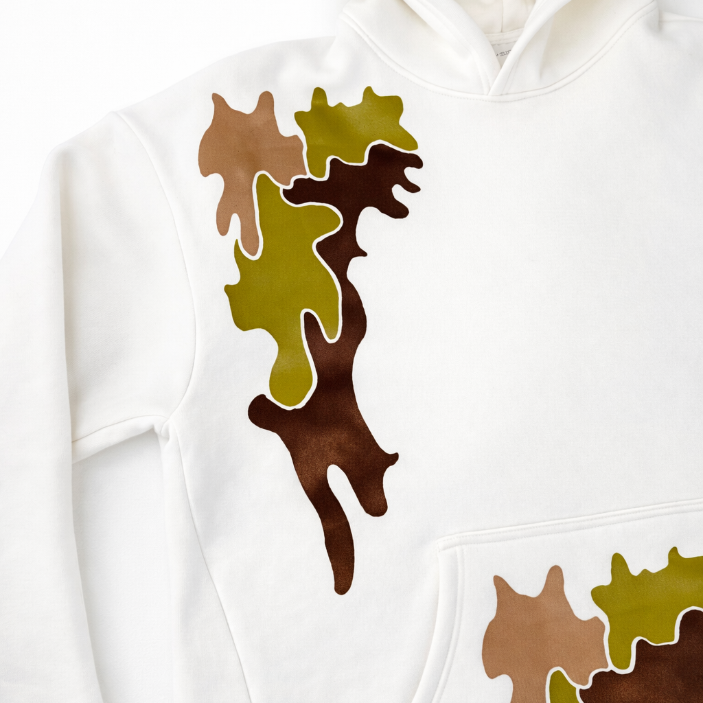 White hoodie with brown and green abstract camouflage patterns on a white background